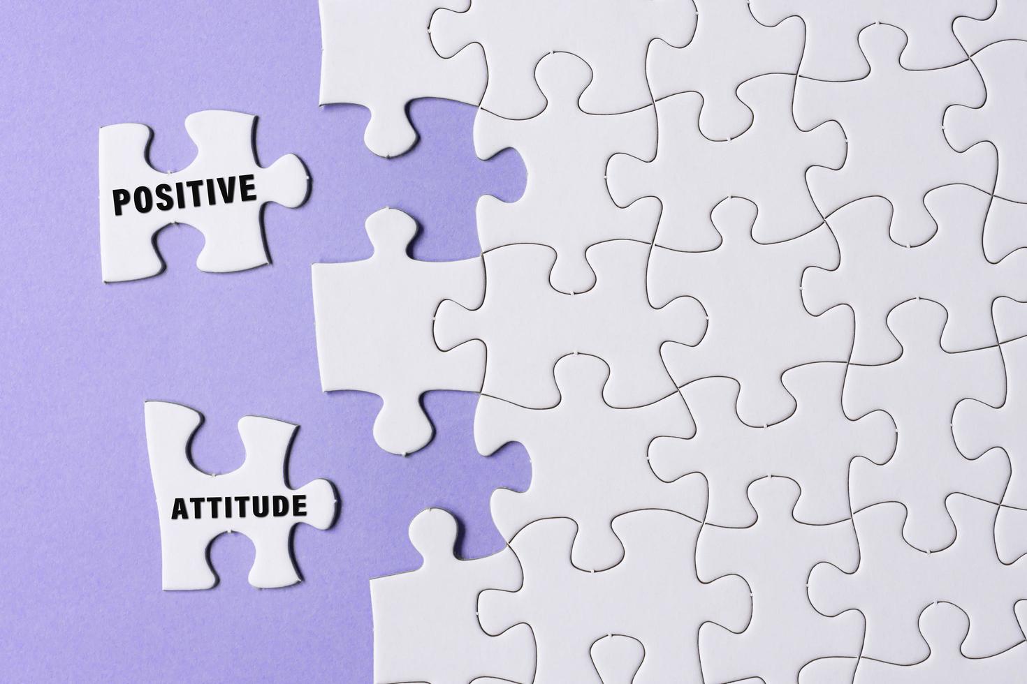 Positive attitude word on white jigsaw puzzle with some missing pieces. photo