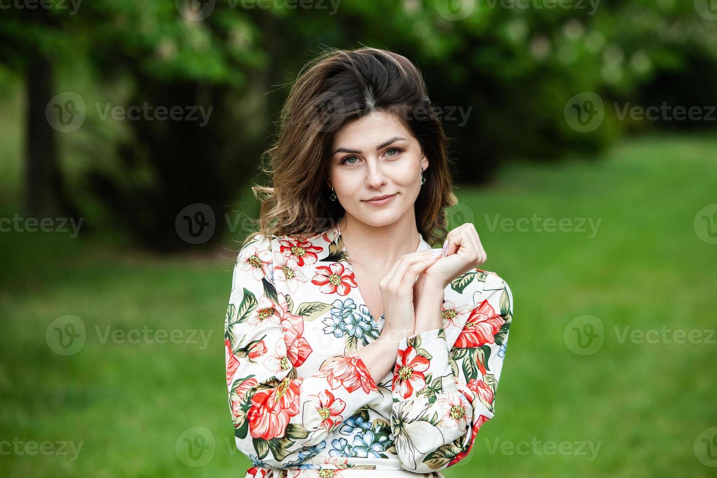 Woman's portrait with a hair moving in the wind.  portrait of young beautiful Russian brunette girl at summer green park. European white woman in dress. photo