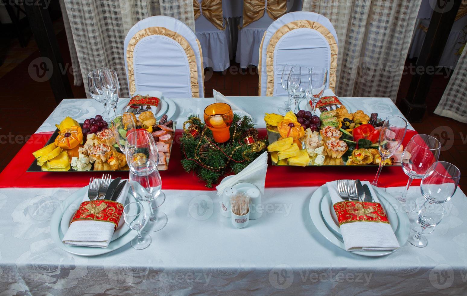 hermosa mesa festiva servida para la cena de celebración de bodas en casa o en el interior del restaurante. mesa llena de comida en un restaurante. mesa redonda completa. foto