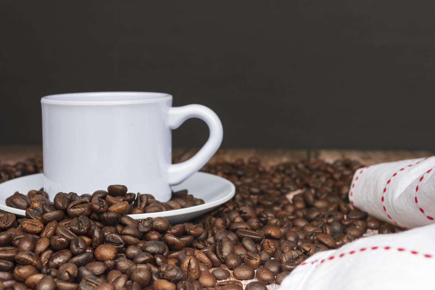 Cup of coffee on coffee beans and blurred background. photo