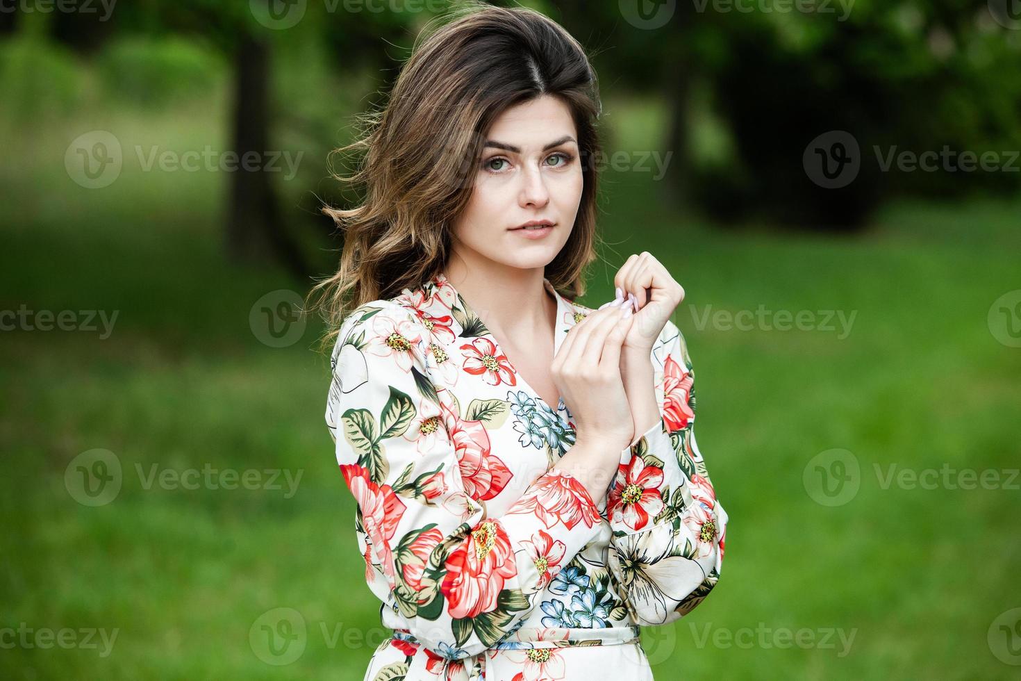 Woman's portrait with a hair moving in the wind.  portrait of young beautiful Russian brunette girl at summer green park. European white woman in dress. photo