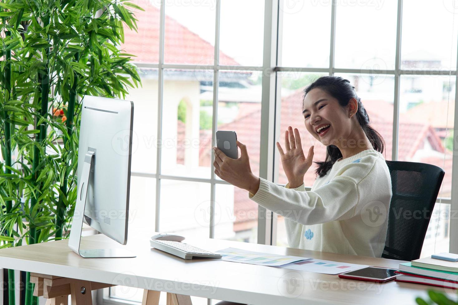 trabajo desde casa y concepto de aprendizaje en línea. mujeres muy jóvenes que trabajan en la computadora miran la pantalla usando un teléfono inteligente en la sala de estar o en el espacio de trabajo conjunto. curso de formación en línea de estudio de estudiantes. foto