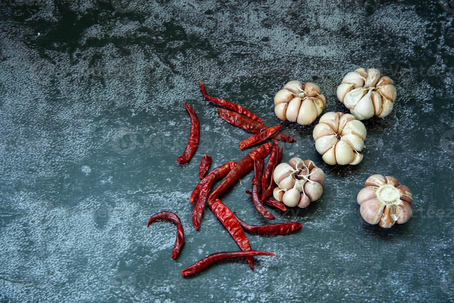 chile rojo seco y ajo sobre fondo de textura gris, el chile y el ajo son ingredientes de la comida tailandesa foto