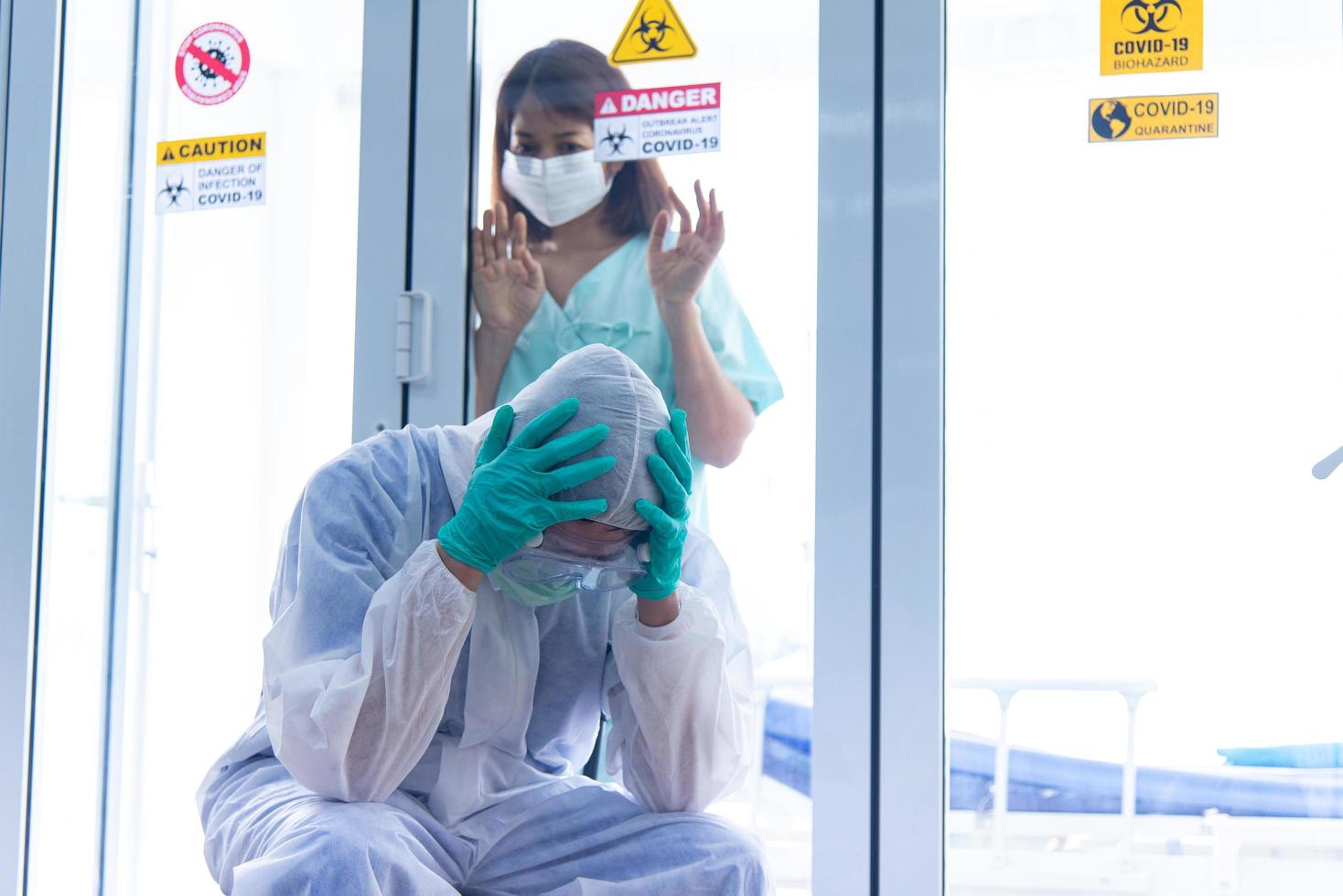 COVID-19, Corona Virus outbreak, quarantine and epidemic spread concept. Asian doctors wear PPE suit, glove and face mask has stress. Doctor has over workload in COVID-19 situation photo