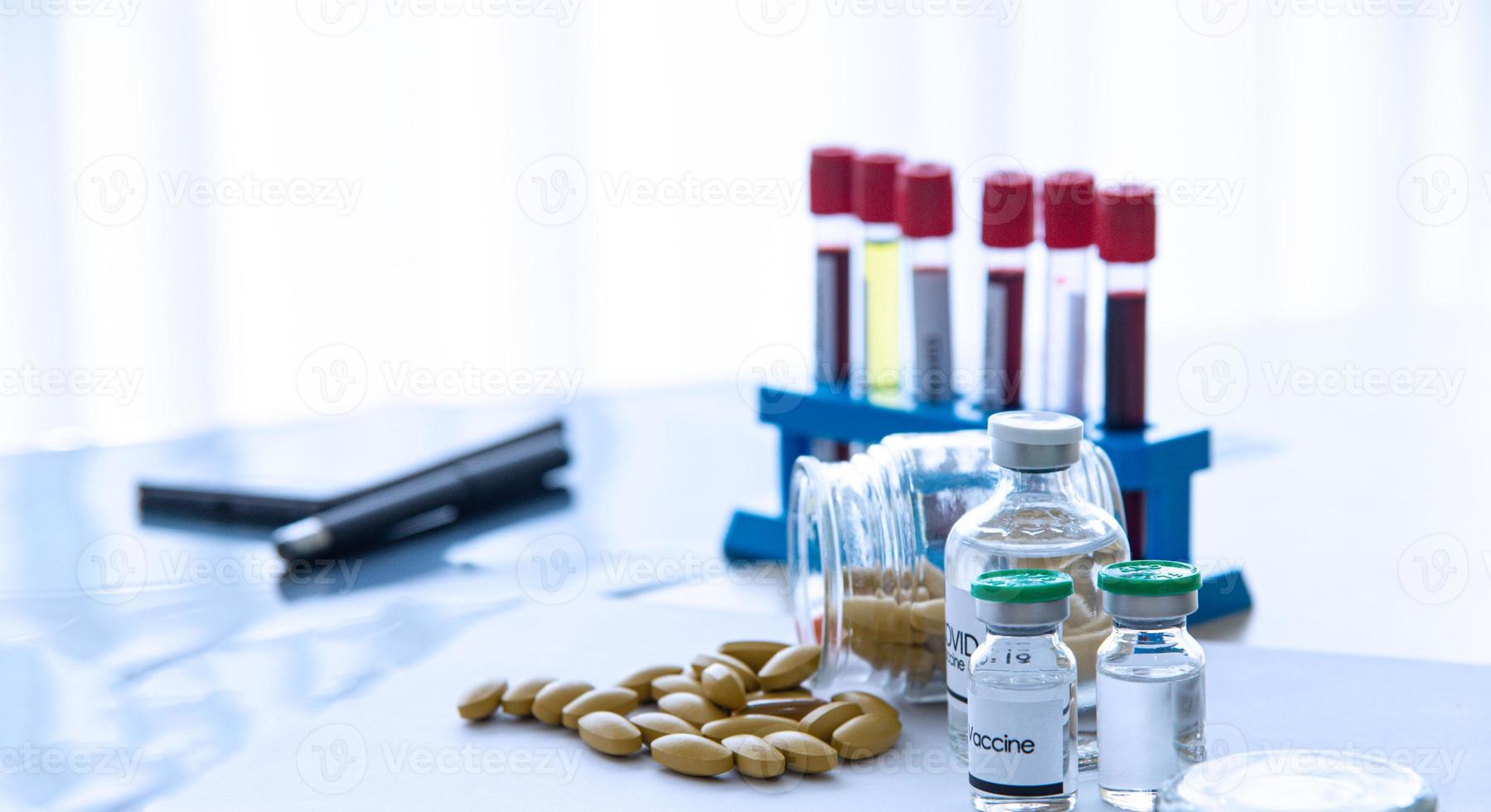 COVID-19 or Coronavirus treatment and preventive concept. Medication tablets for virus infection symptoms. Coronavirus vaccine and positive patient infection sample blood testing in laboratory. photo