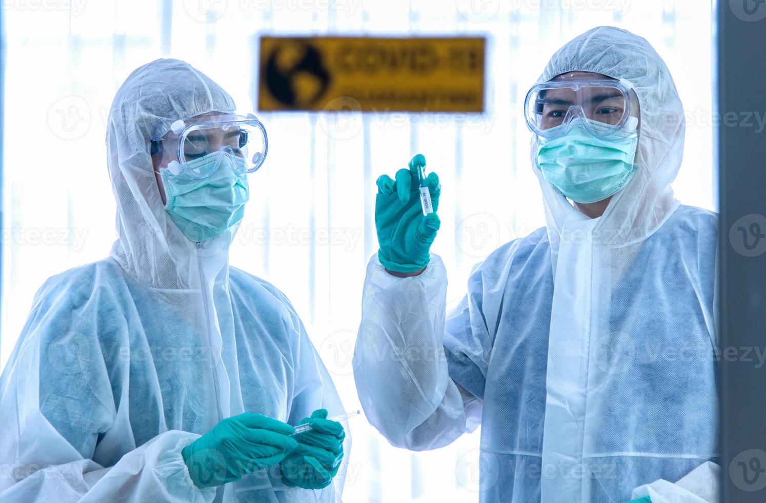 COVID-19, Corona Virus outbreak quarantine epidemic spread  social distancing concept. Asian doctors wear PPE suit glove and face mask showing CORONA or COVID-19 vaccine and treat patient infection. photo