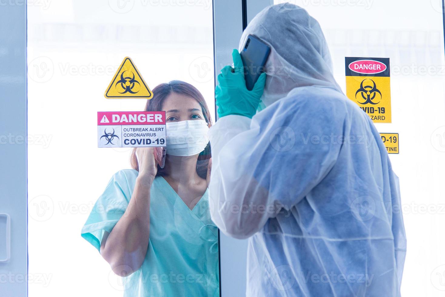 COVID-19, Corona Virus outbreak quarantine epidemic spread and social distancing concept. Asian doctors wear PPE  monitor patient health and encourage depressed CORONA or COVID-19 patient infection photo