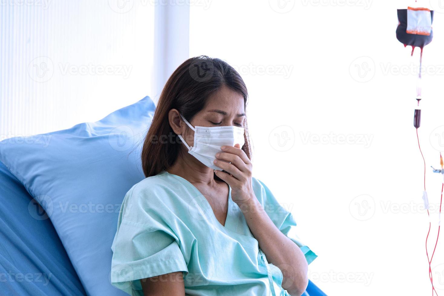 COVID-19, Corona Virus outbreak, quarantine and epidemic spread concept. Asian depressed CORONA or COVID-19 patient infection wear mask and get blood transfusion in quarantine room at the hospital photo