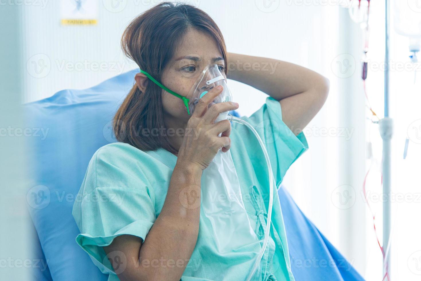 COVID-19, Corona Virus outbreak, quarantine and epidemic spread concept. Asian depressed CORONA or COVID-19 patient infection wear oxiygen mask with bag in quarantine room at the hospital photo