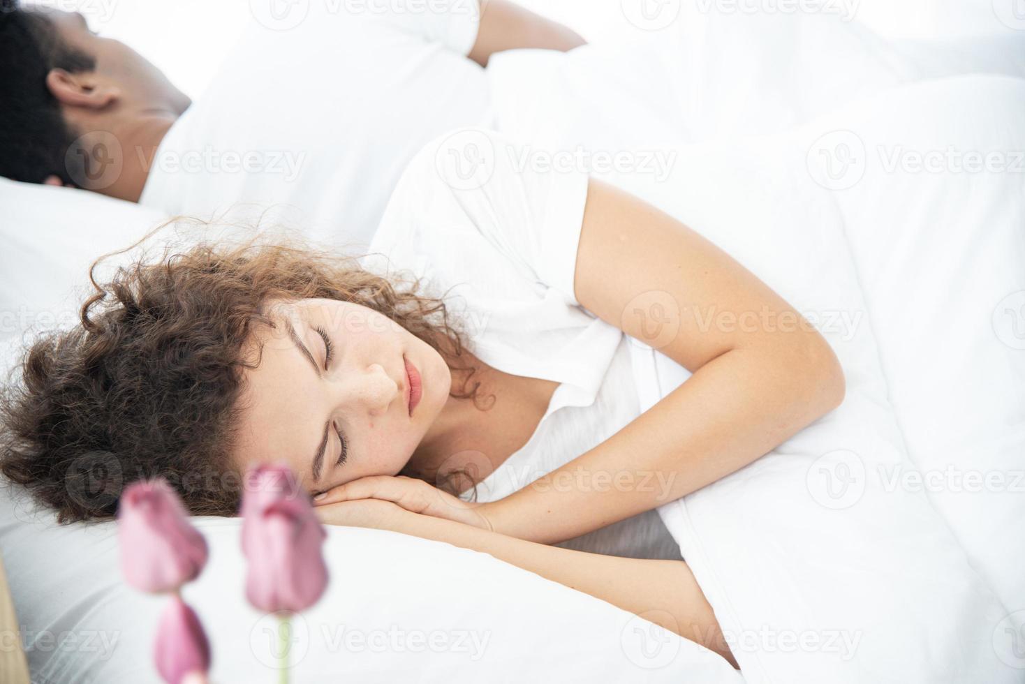 Lover concept. Young attractive couple lying under white blanket in bed photo