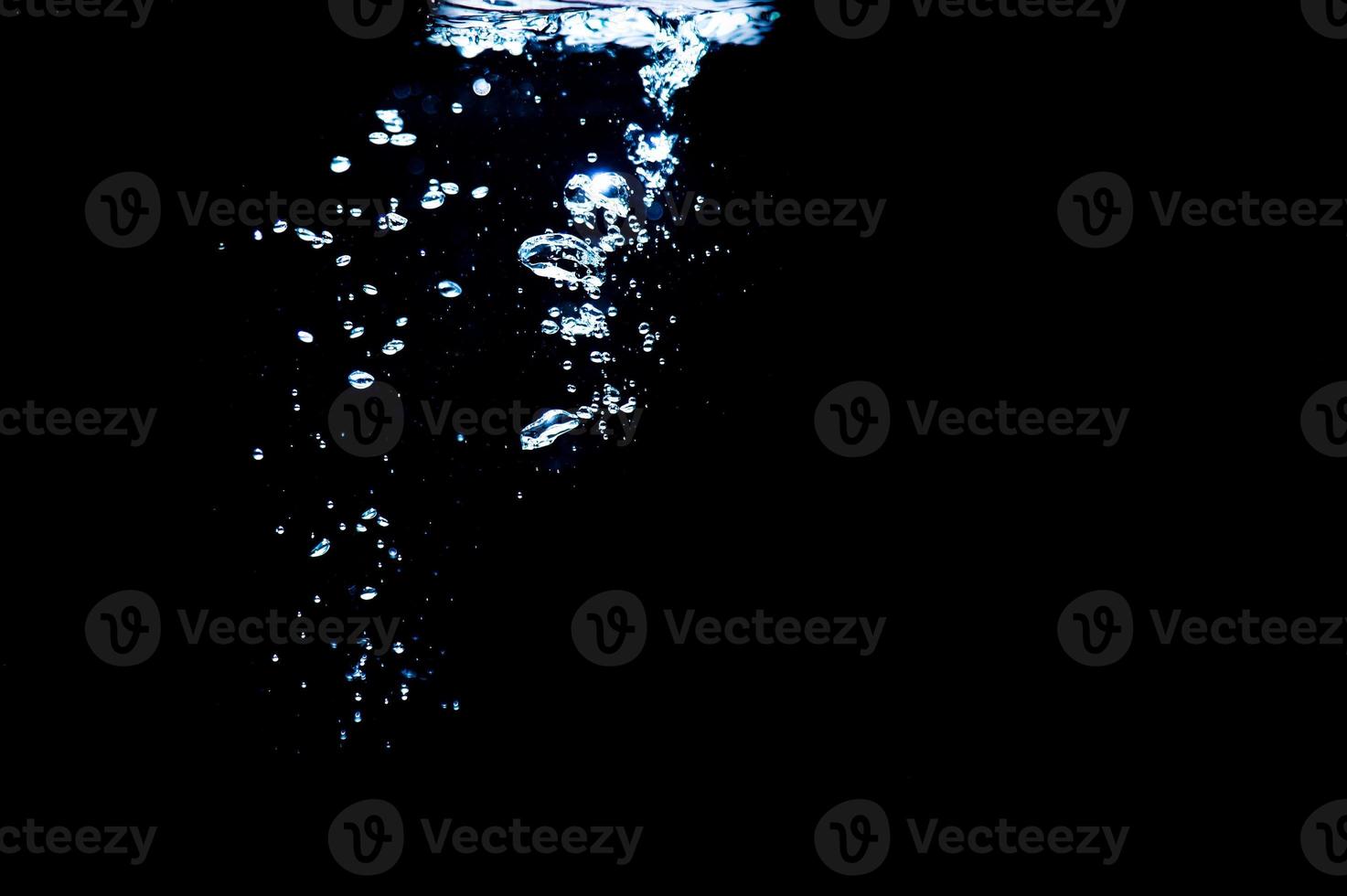 Water bubbles isolated on black background, close up view. Rippling liquid surface, an abstract background for overlays design photo