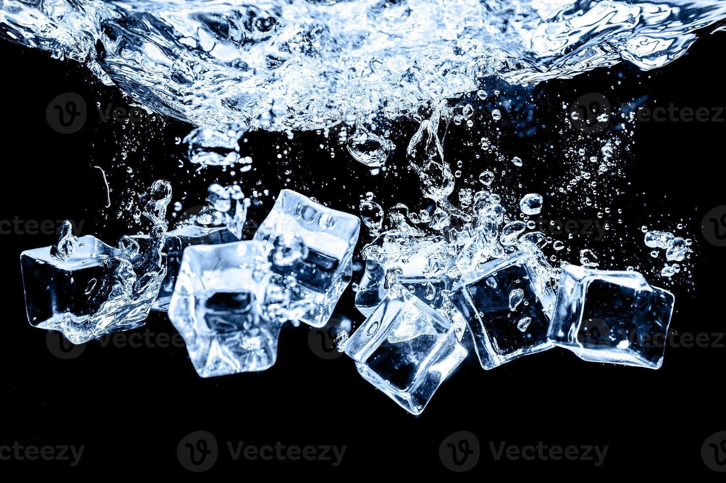 cubos de hielo en agua sobre fondo oscuro de estudio. el concepto de frescura con frialdad de cubitos de hielo. foto