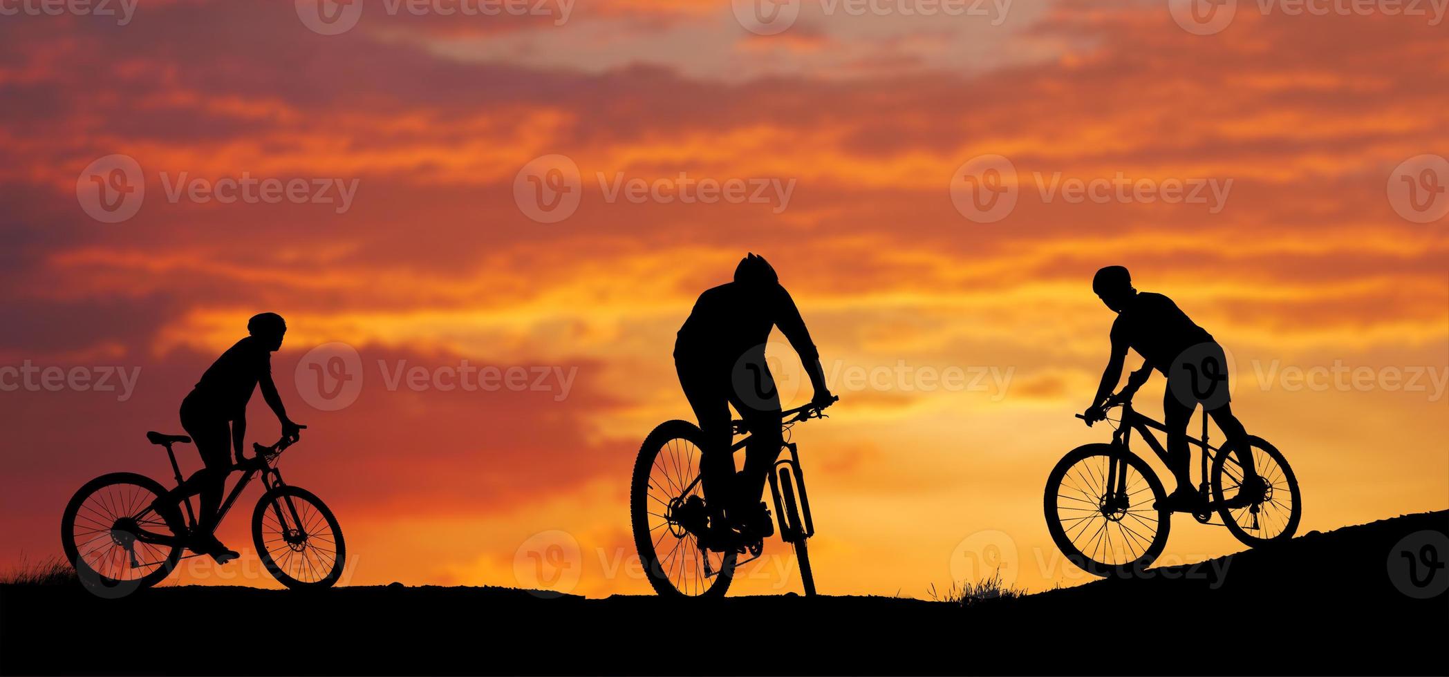 silueta de un ciclista de montaña disfrutando cuesta abajo durante la puesta de sol. concepto de bicicleta de montaña. carrera de bicicleta de montaña - ciclista de silueta en el fondo. foto