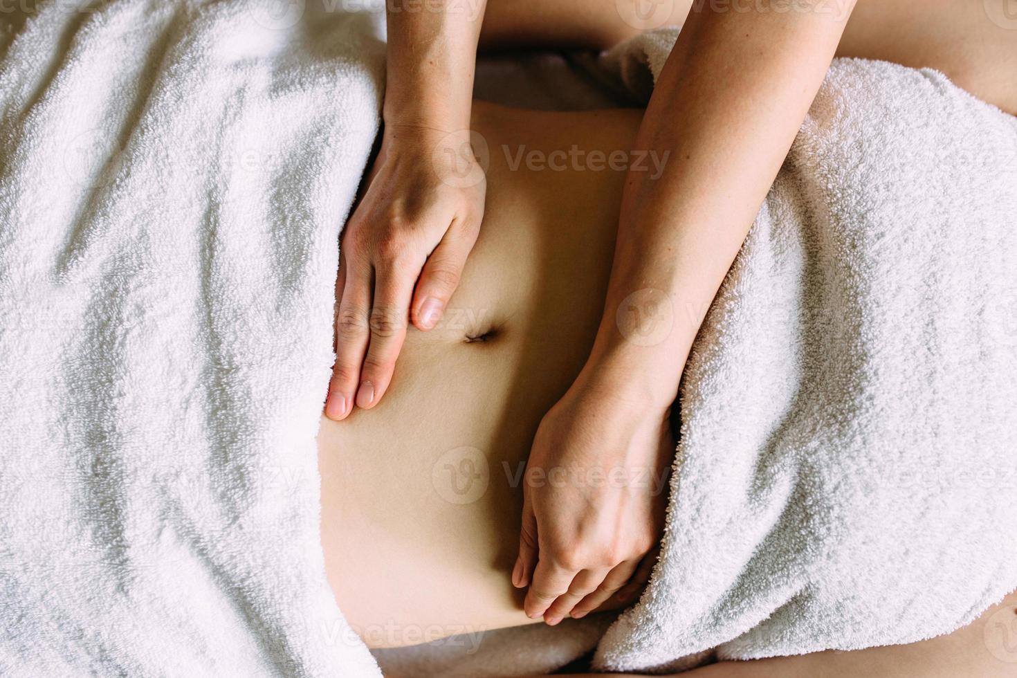 The masseur gives a massage to the female belly at the spa. The concept of cosmetic procedures. photo