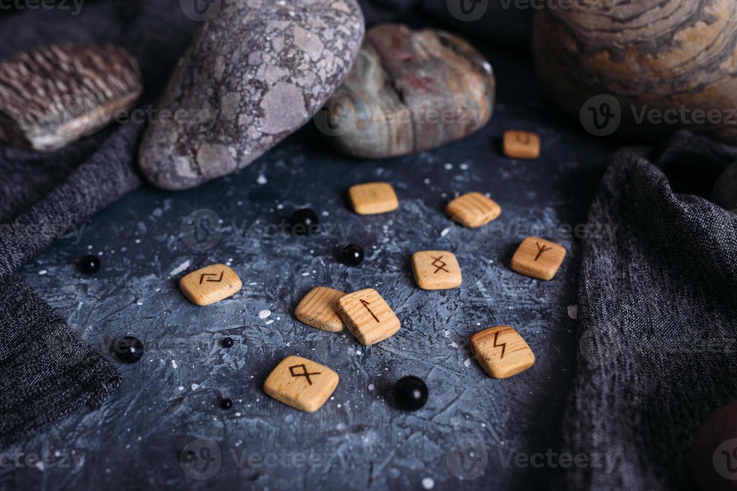 Fortune telling on wooden runes among stones. Gloomy and mysterious witch table. photo