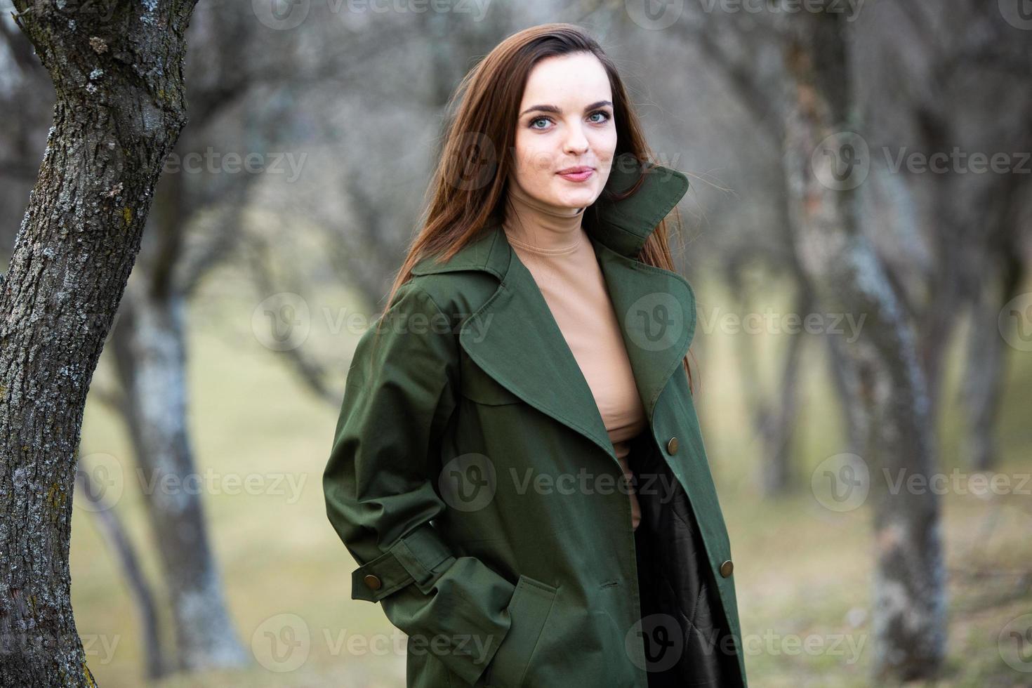 imagen de una mujer hermosa joven que usa una chaqueta para la lluvia cuando hace frío. pensadora chica europea en la naturaleza de primavera. foto