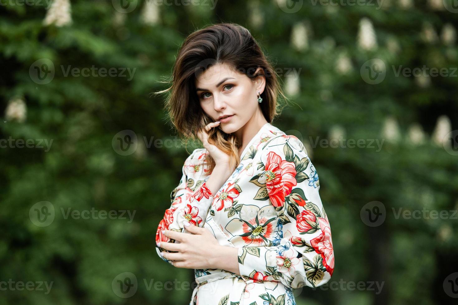 Woman's portrait with a hair moving in the wind.  portrait of young beautiful Russian brunette girl at summer green park. European white woman in dress. photo