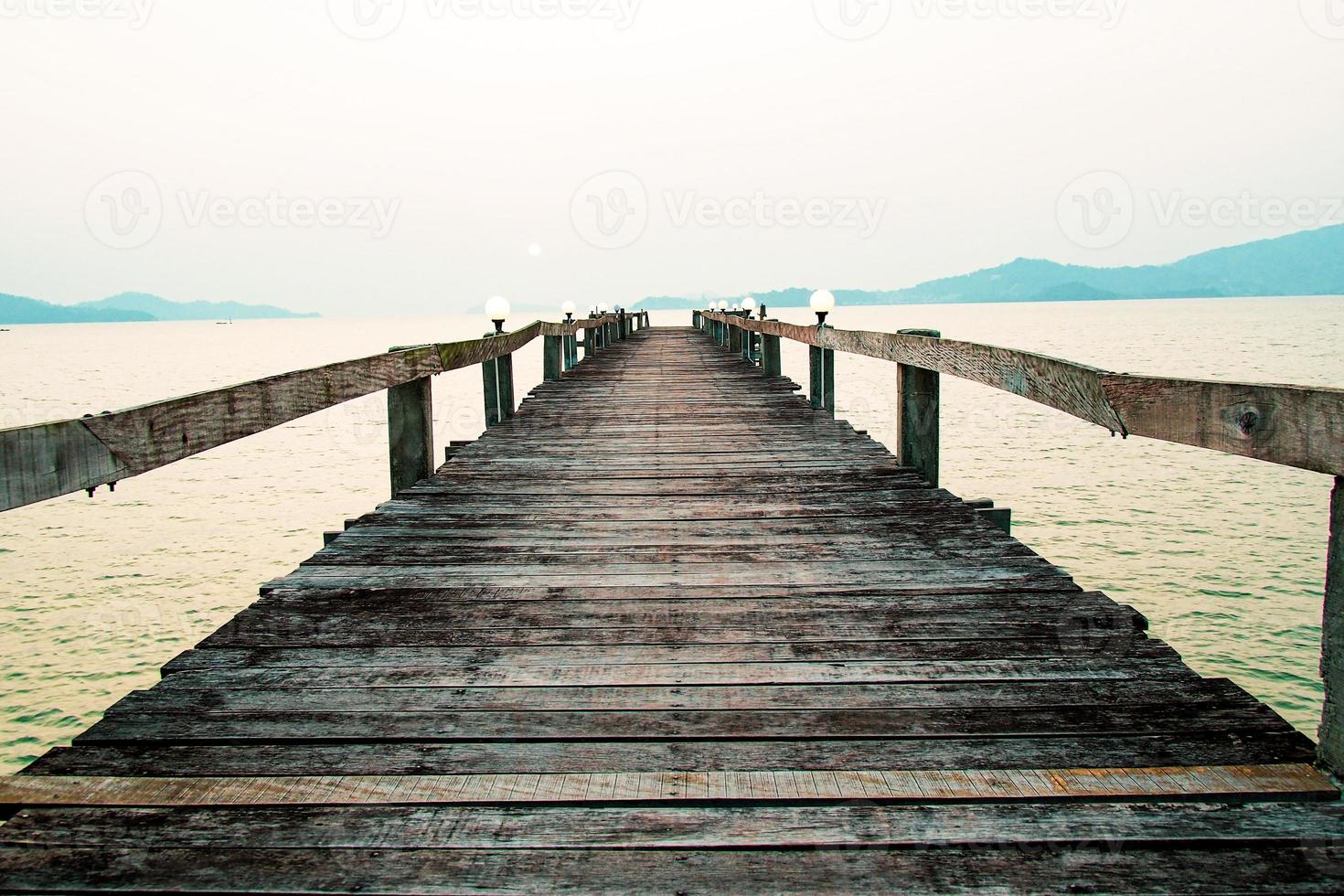 una pasarela de madera que se adentra en el mar. concepto de viaje de vacaciones foto