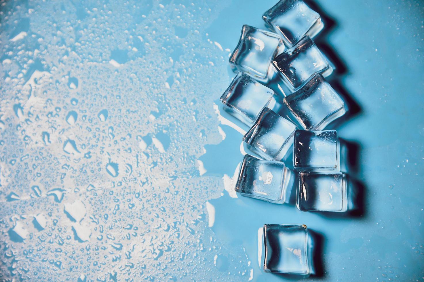 cubitos de hielo sobre fondo azul de estudio. el concepto de frescura con frialdad de cubitos de hielo. foto