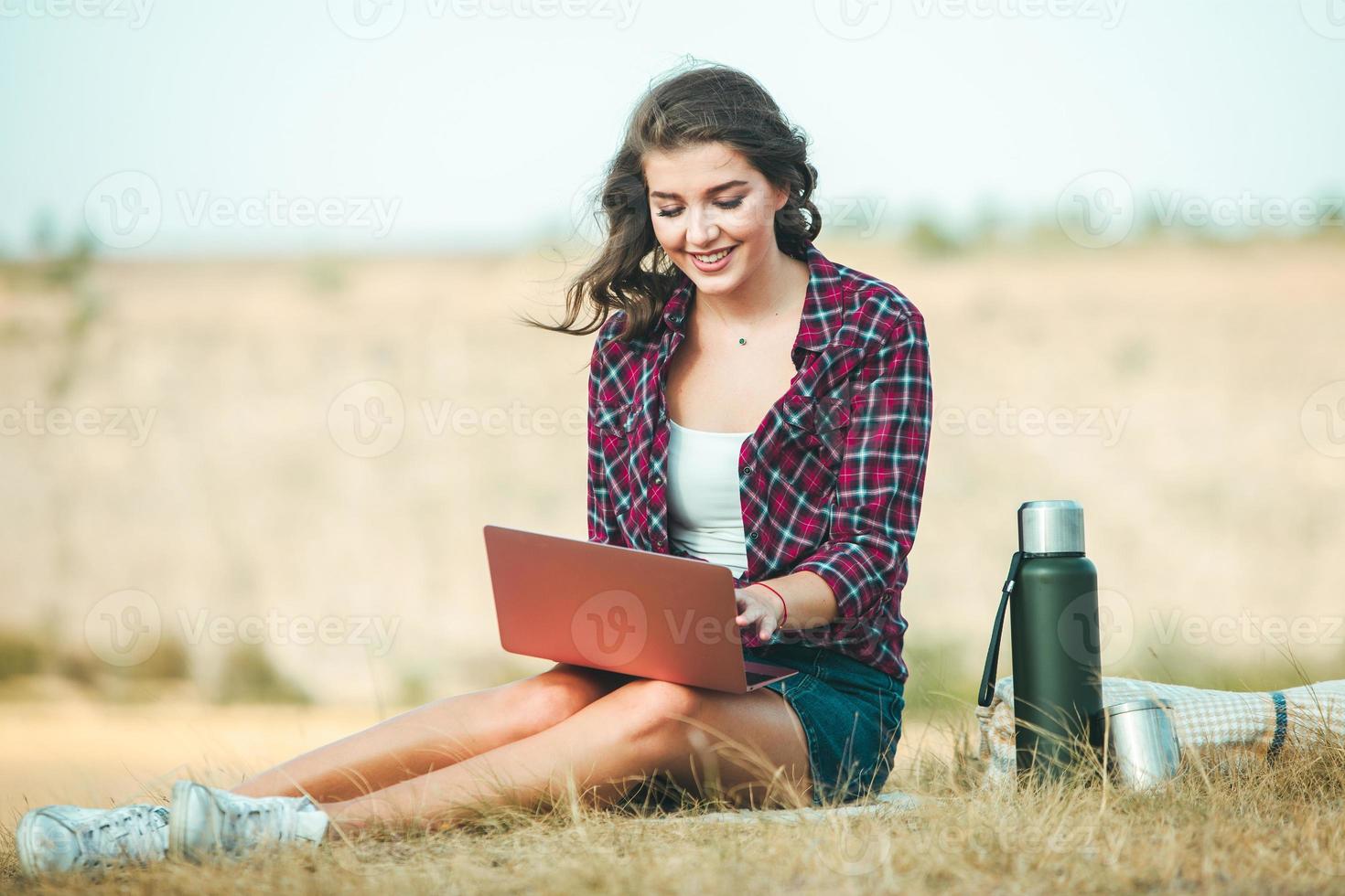 Office outdoors. Beautiful girl works on a laptop in the open air. woman freelancer. Freelance worker concept. photo