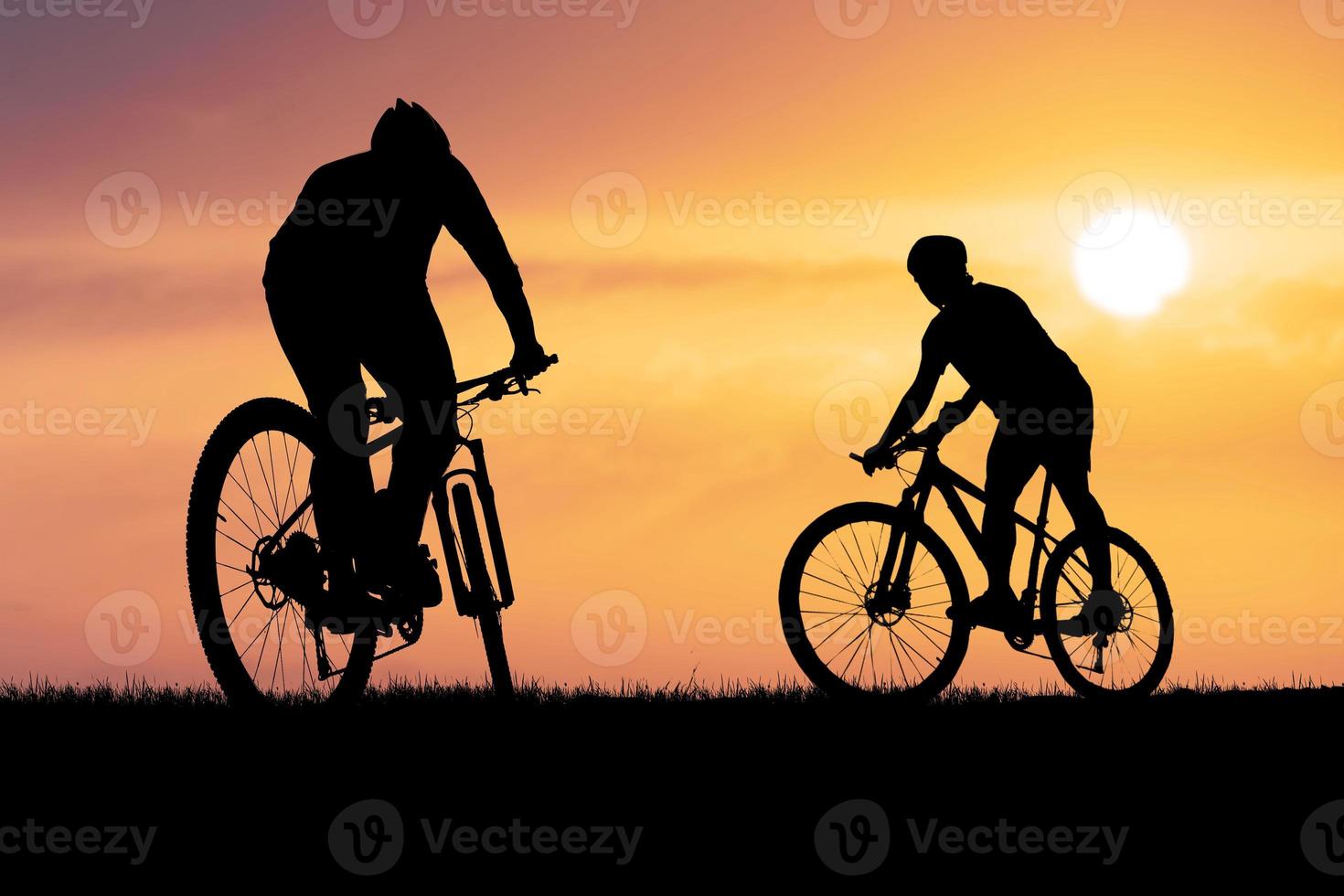 Silhouettes of mountain bikes and cyclists in the evening happily. Travel and fitness concept photo