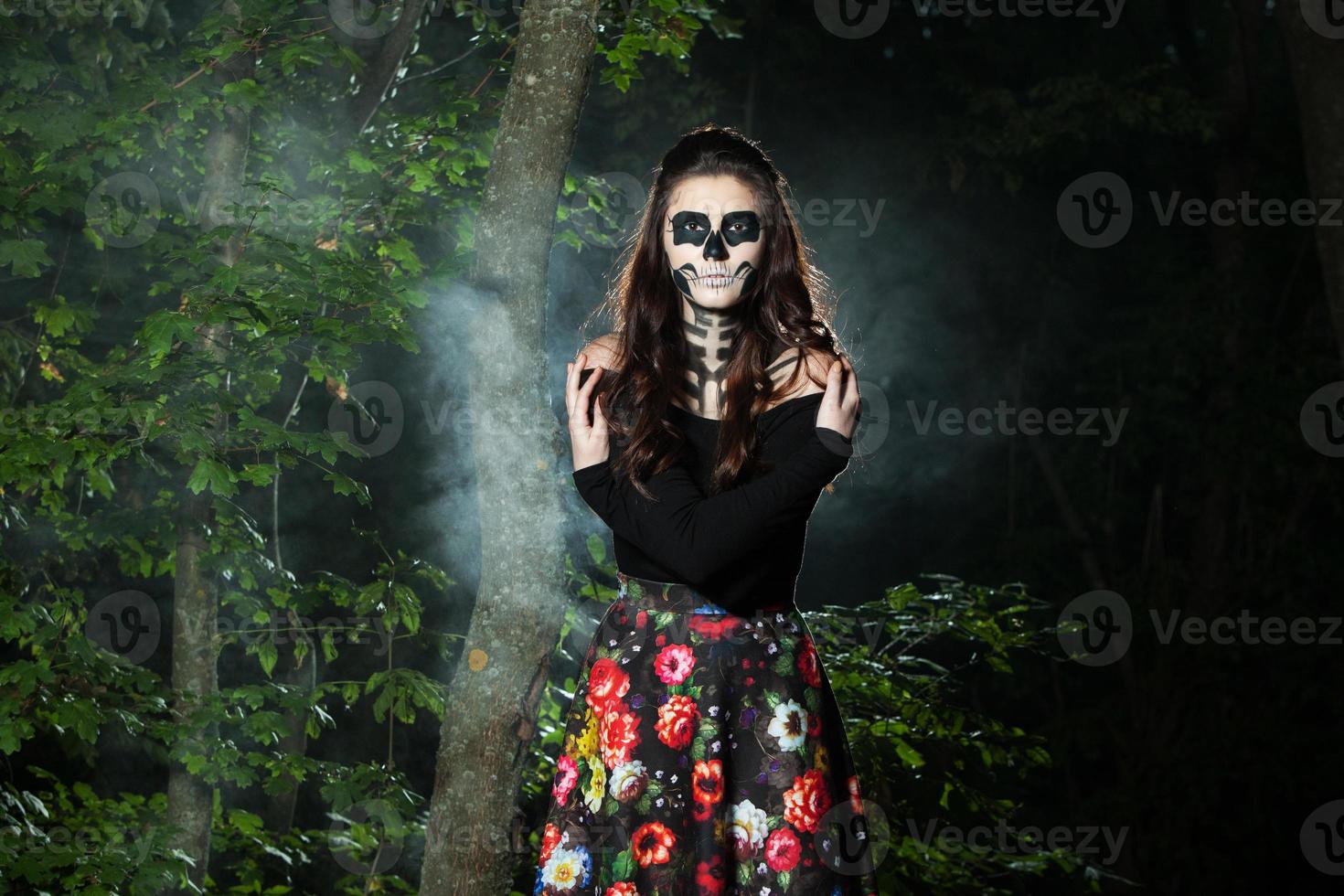 Halloween Vampire Woman portrait over scary night background. Vampire makeup Fashion Art design. Model girl in Halloween costume and make up. photo