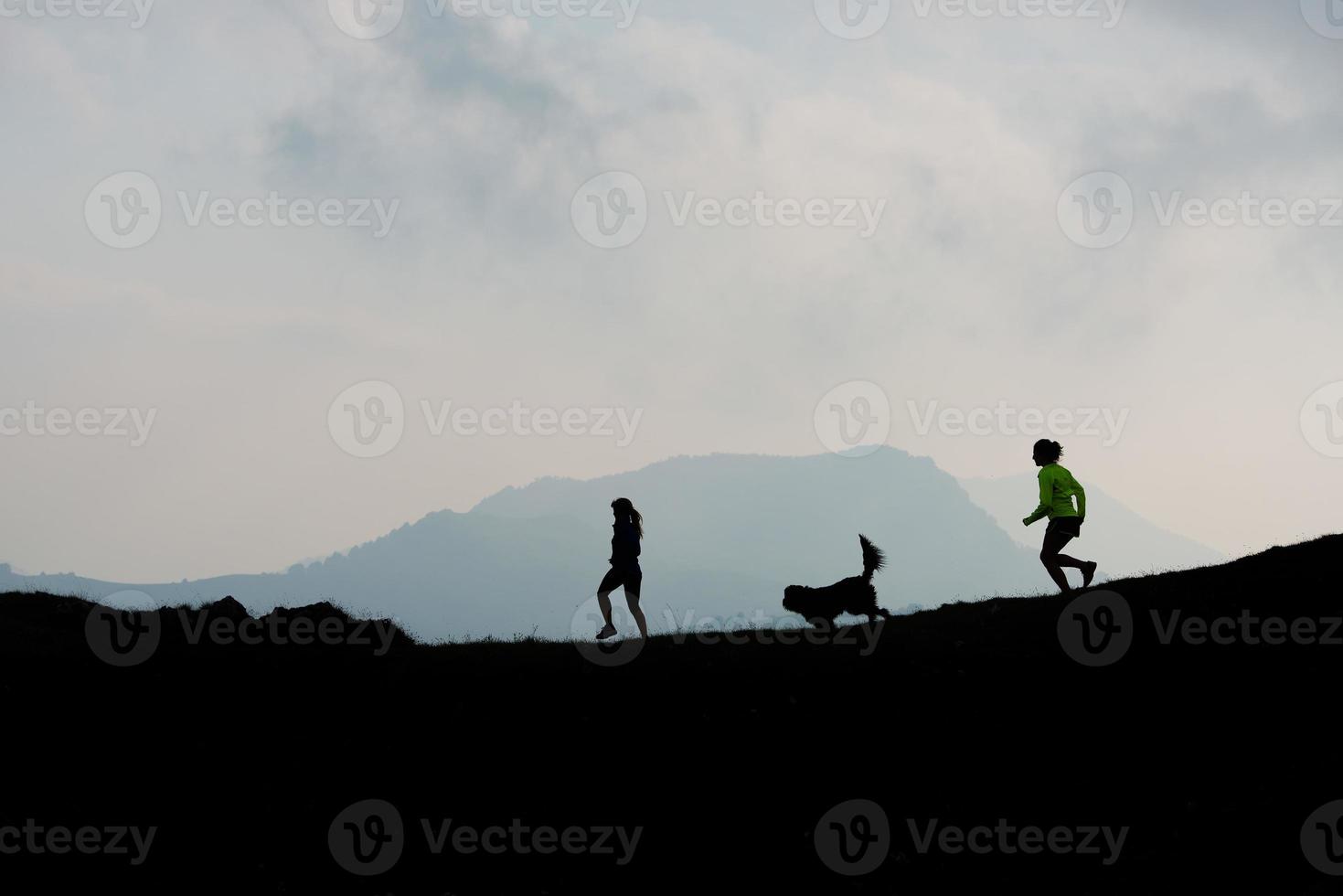 Two women race in the mountains with a dog photo