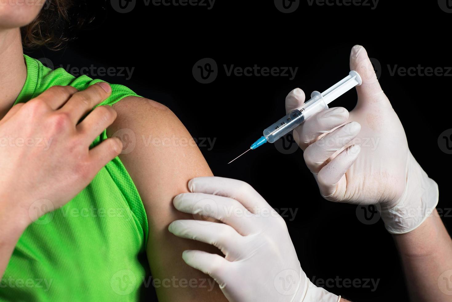 Close-up of a medical man doing an injection photo