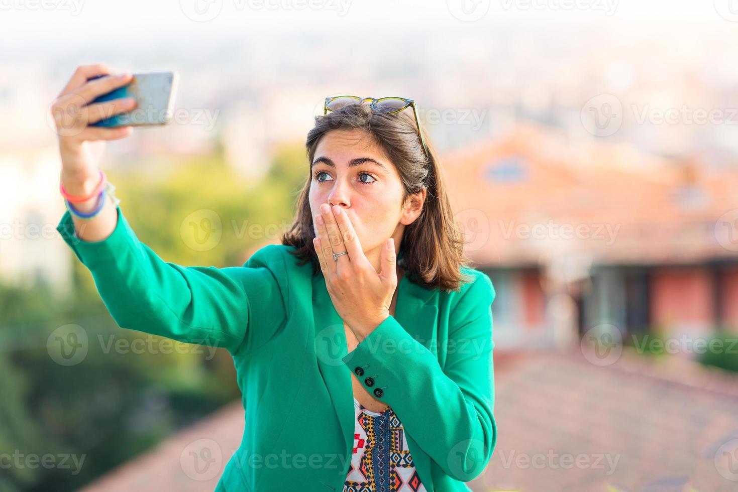 Young beautiful girl taking sends a kiss away selfies with mobil photo