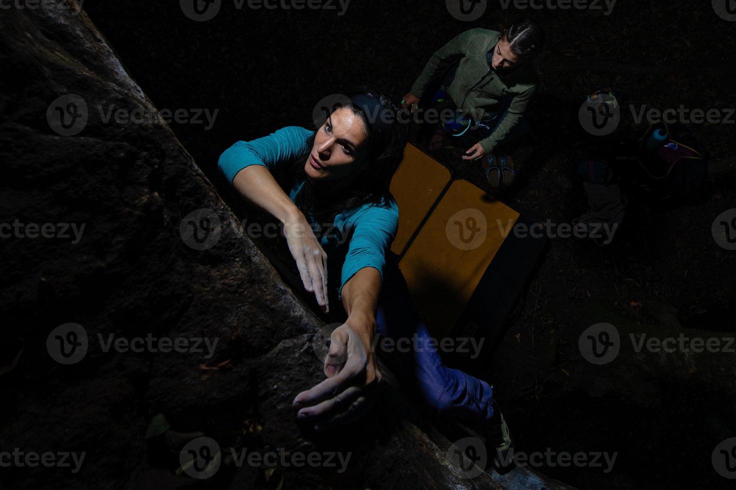 Two girls practice bouldering in the evening photo