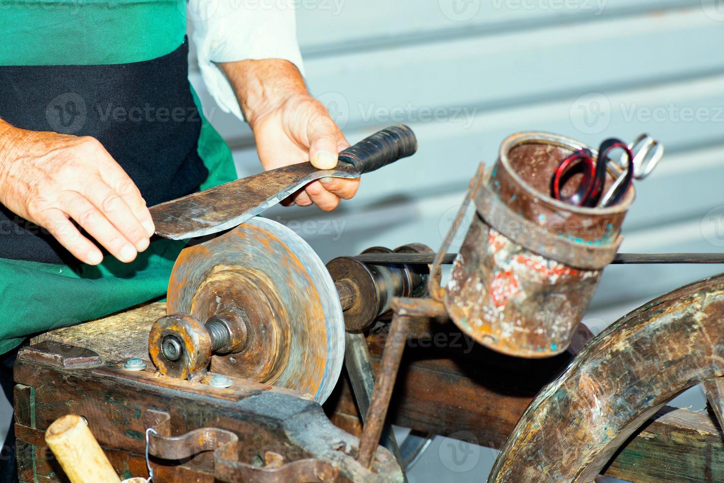 Blade tool sharpening with vintage grinding wheel photo