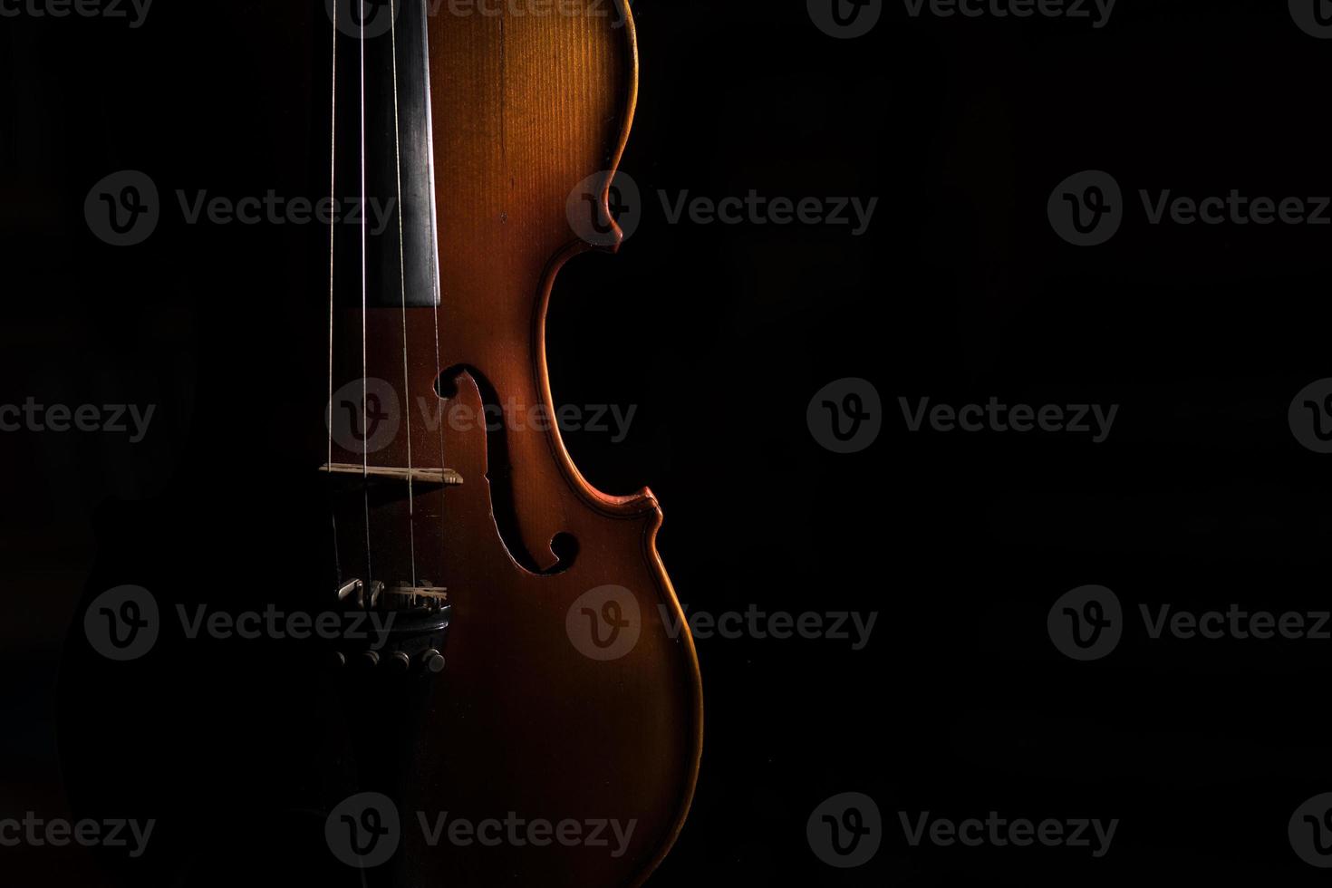 Violin on a black background lit from one side photo