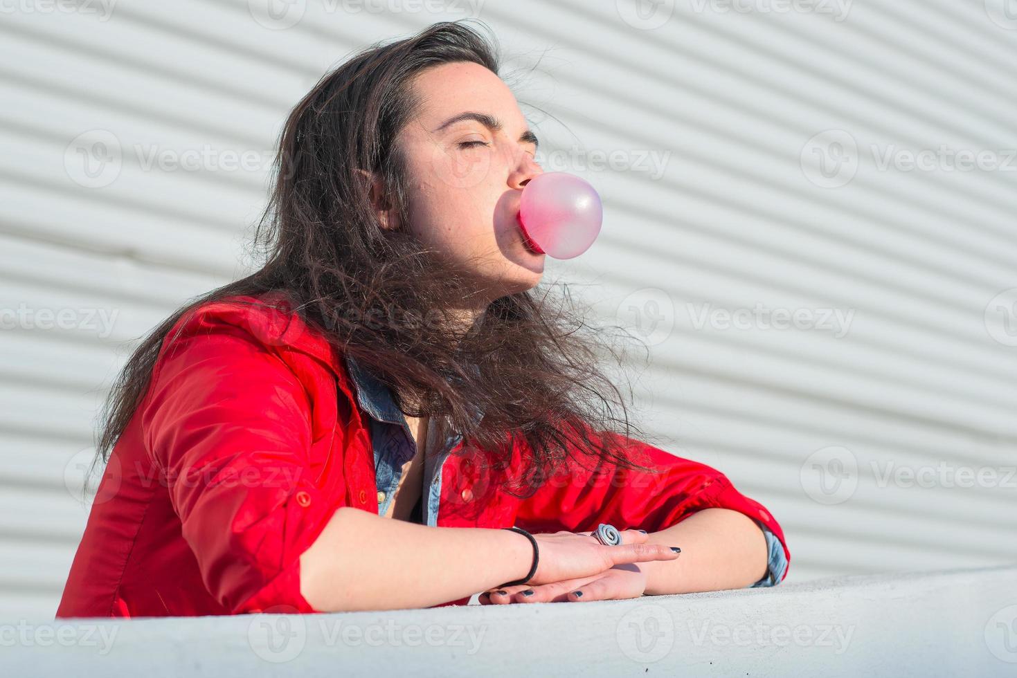 Girl Beautiful young woman blowing a bubble gum balloon photo