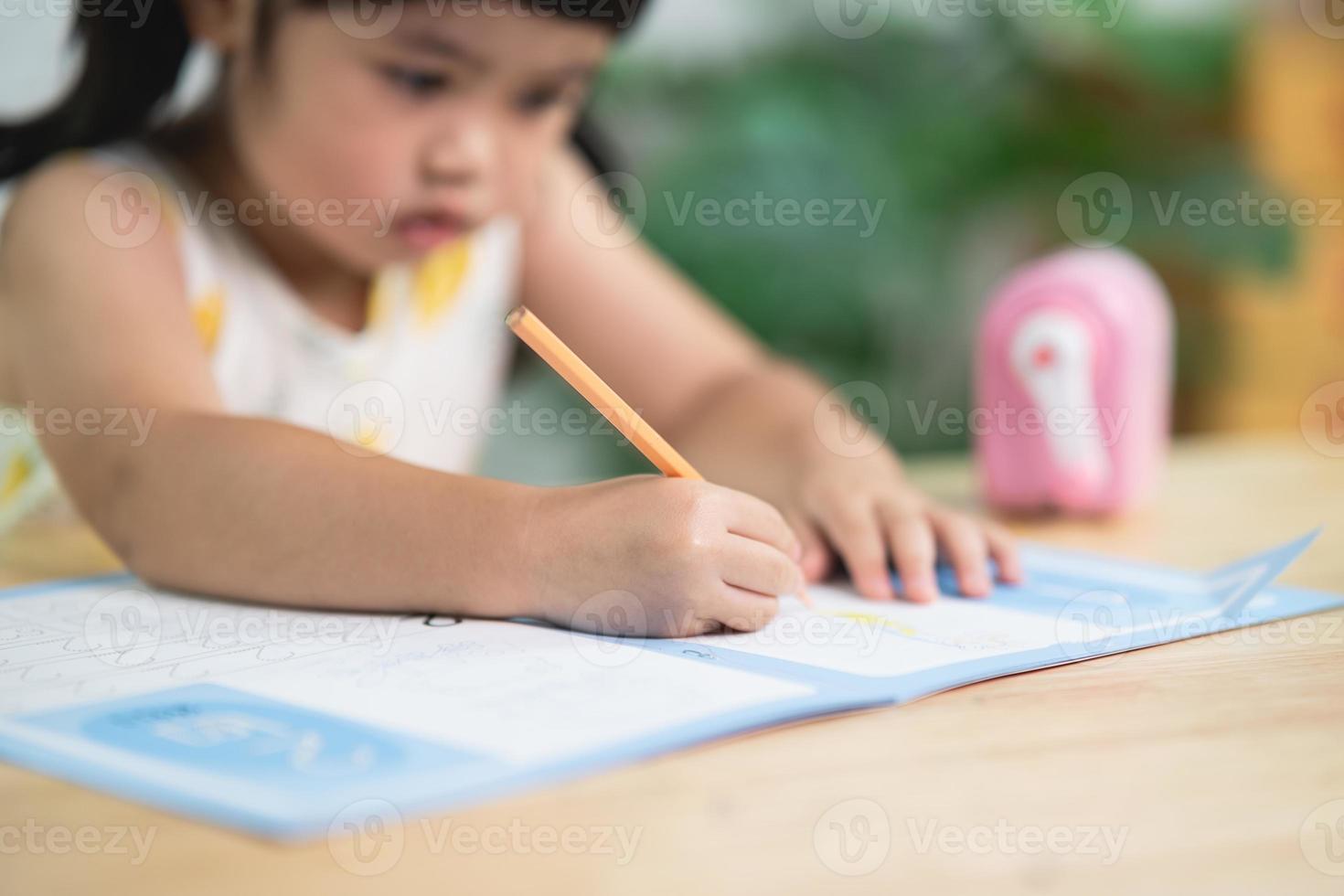 close up hand cute little child use wood color painting with colorful paints. Asian girl using wood color drawing color.Baby artist activity lifestyle concept. photo