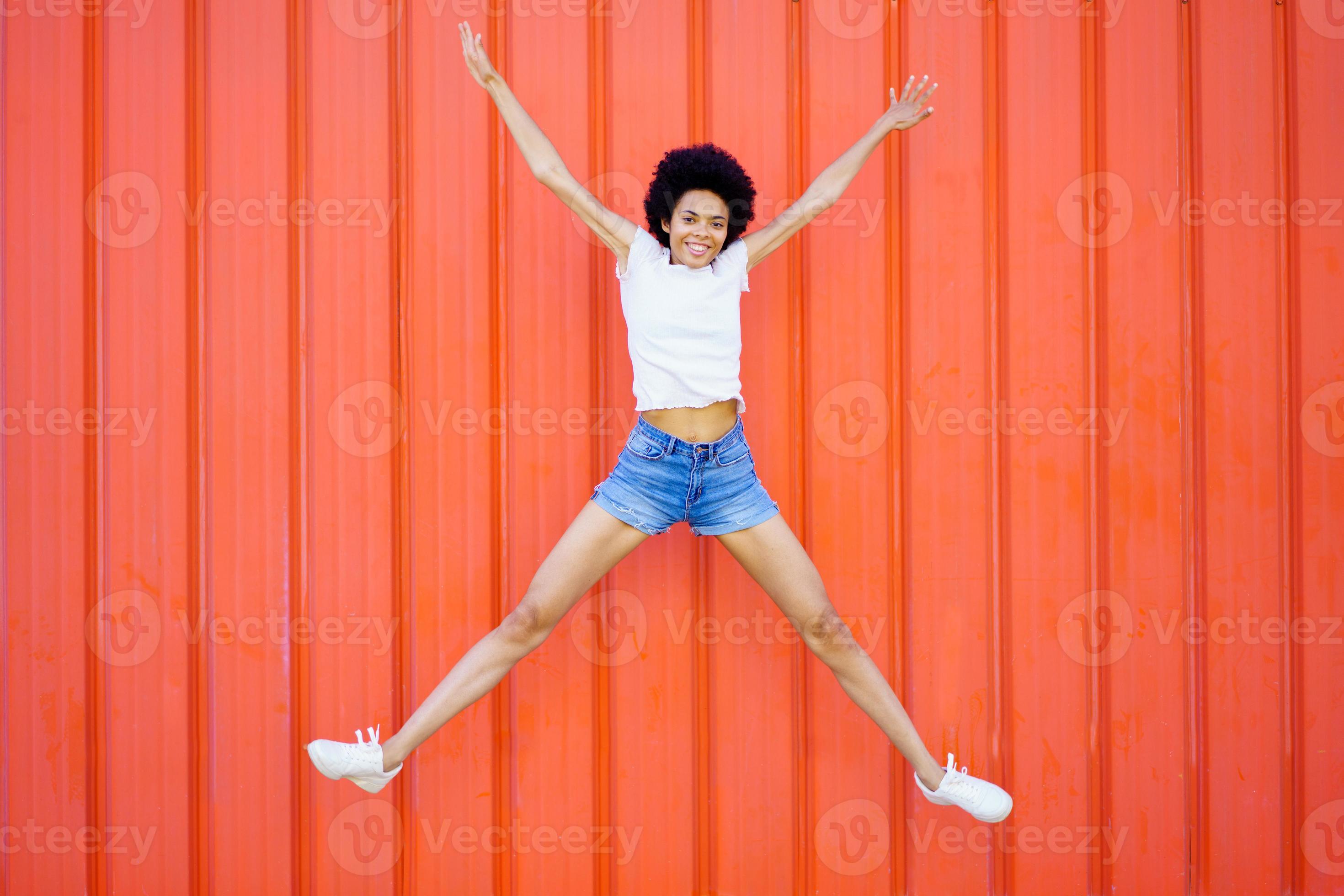 Happy black woman jumping on street 9275074 Stock Photo at Vecteezy