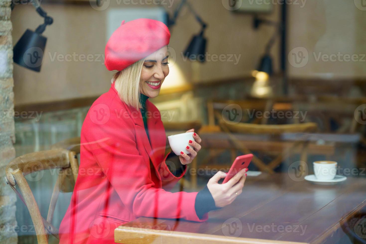 Elegant positive woman with coffee surfing smartphone photo