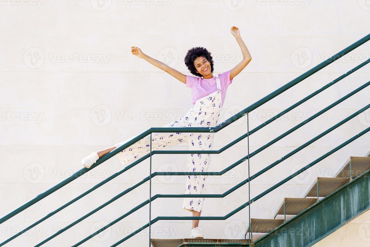 mujer negra divertida parada en la escalera foto