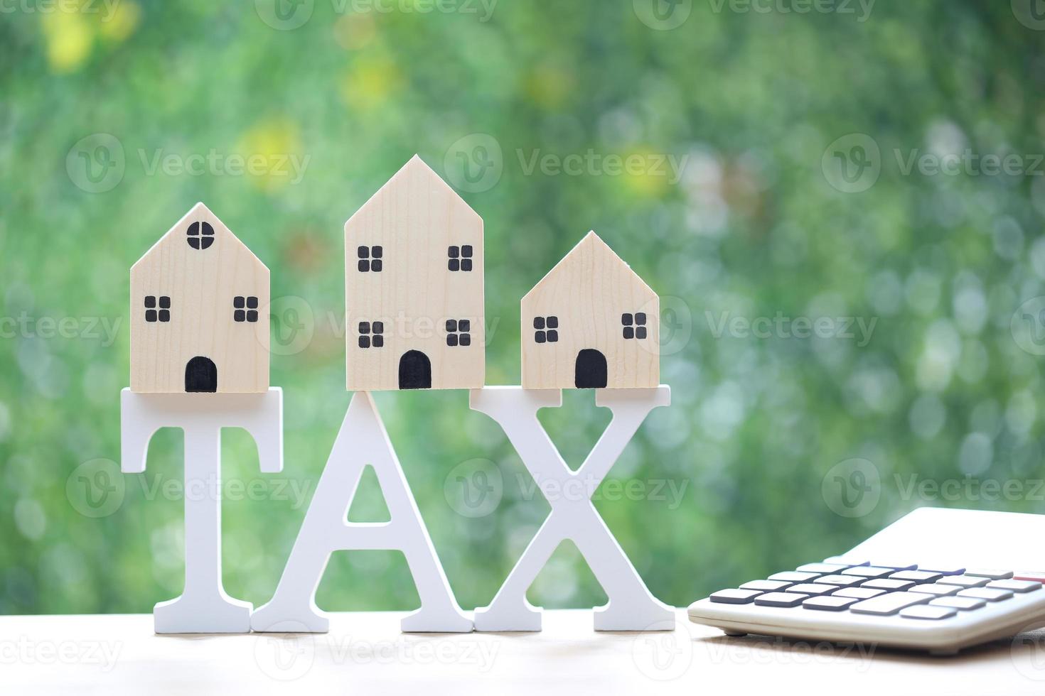 Estate tax,Model house on tax word and calculator on natural green background,Business investment and Property tax concept photo