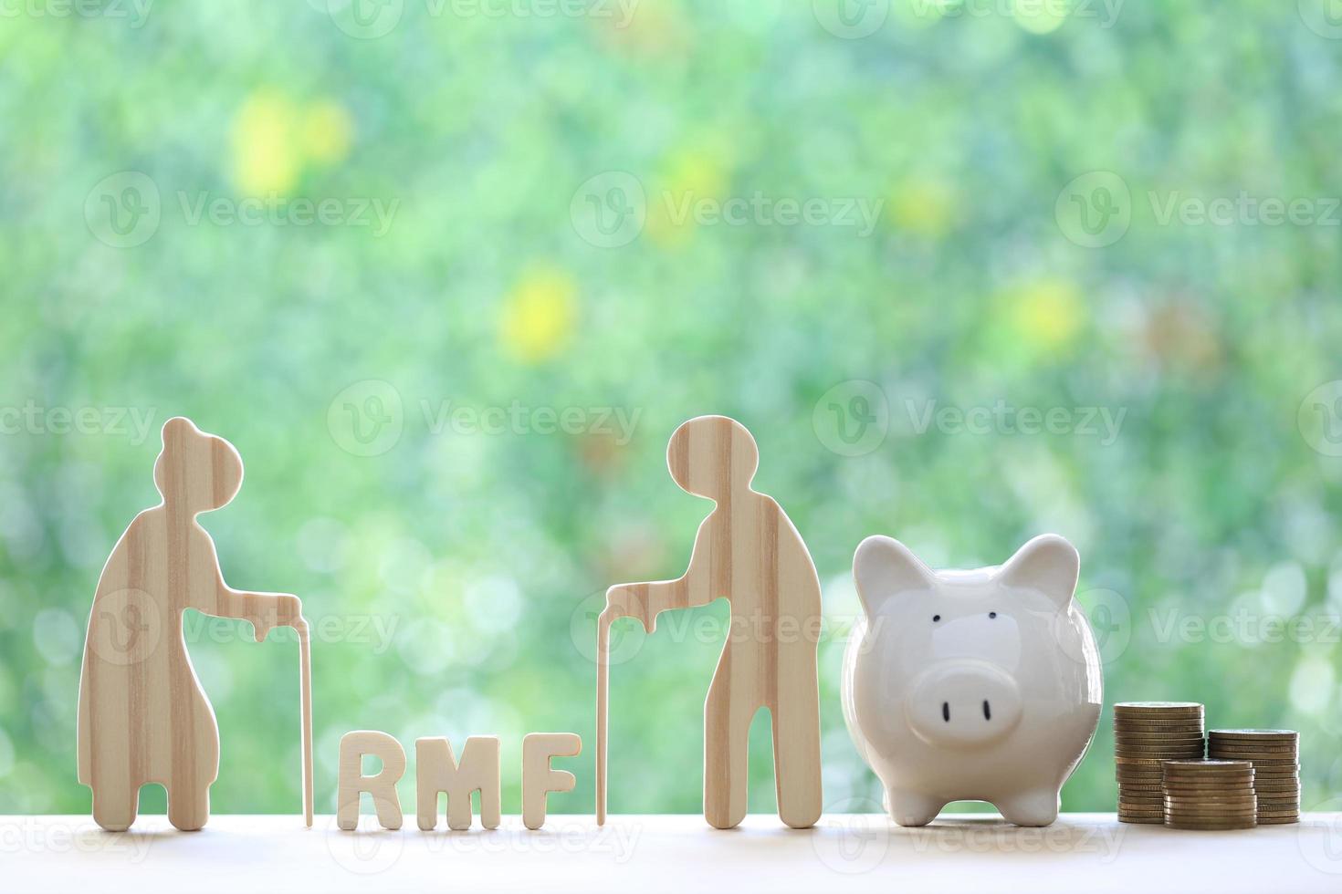 RMF - Retirement Mutual Fund, Senior man with RMF word and stack of coins money with piggy bank on natural green background, Save money for prepare in future and pension retirement concept photo