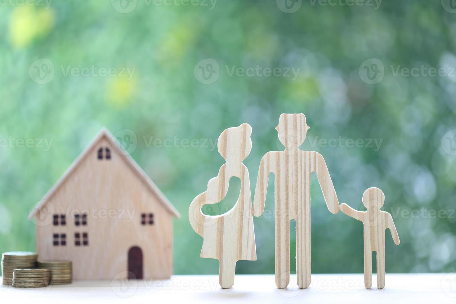 Happy family with model house and gold coin money in the glass bottle on natural green background, Save money for prepare in future and newborn baby concept photo