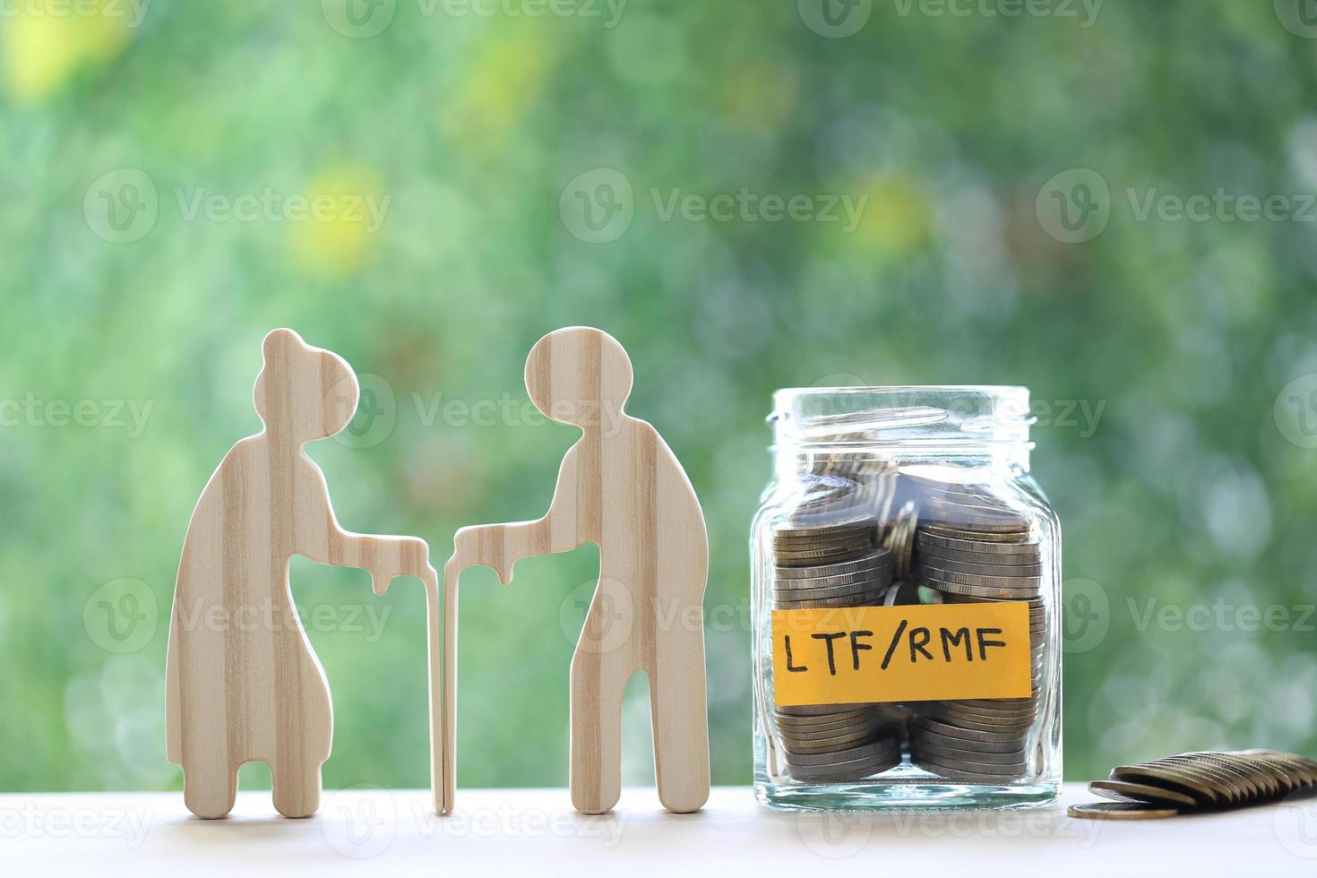RMF - Retirement Mutual Fund, Love couple senior and model house with stack of coins money in glass bottle on natural green background, Save money for prepare in future and pension retirement concept photo