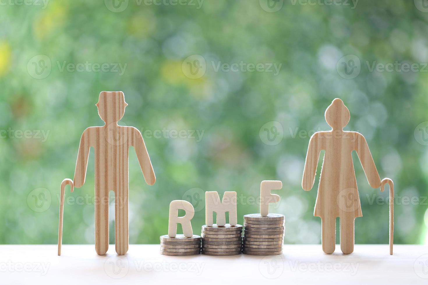 RMF - Retirement Mutual Fund, Love couple senior with RMF word on stack of coins money on natural green background, Save money for prepare in future and pension retirement concept photo
