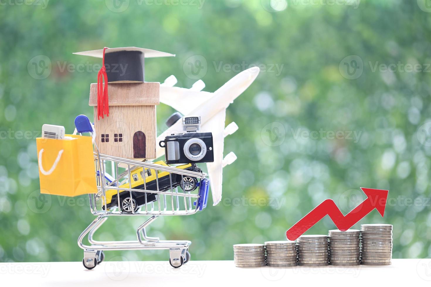 Inflation financial crisis concept, Model house or property on model miniature shopping cart and red arrow graph on natural green background photo