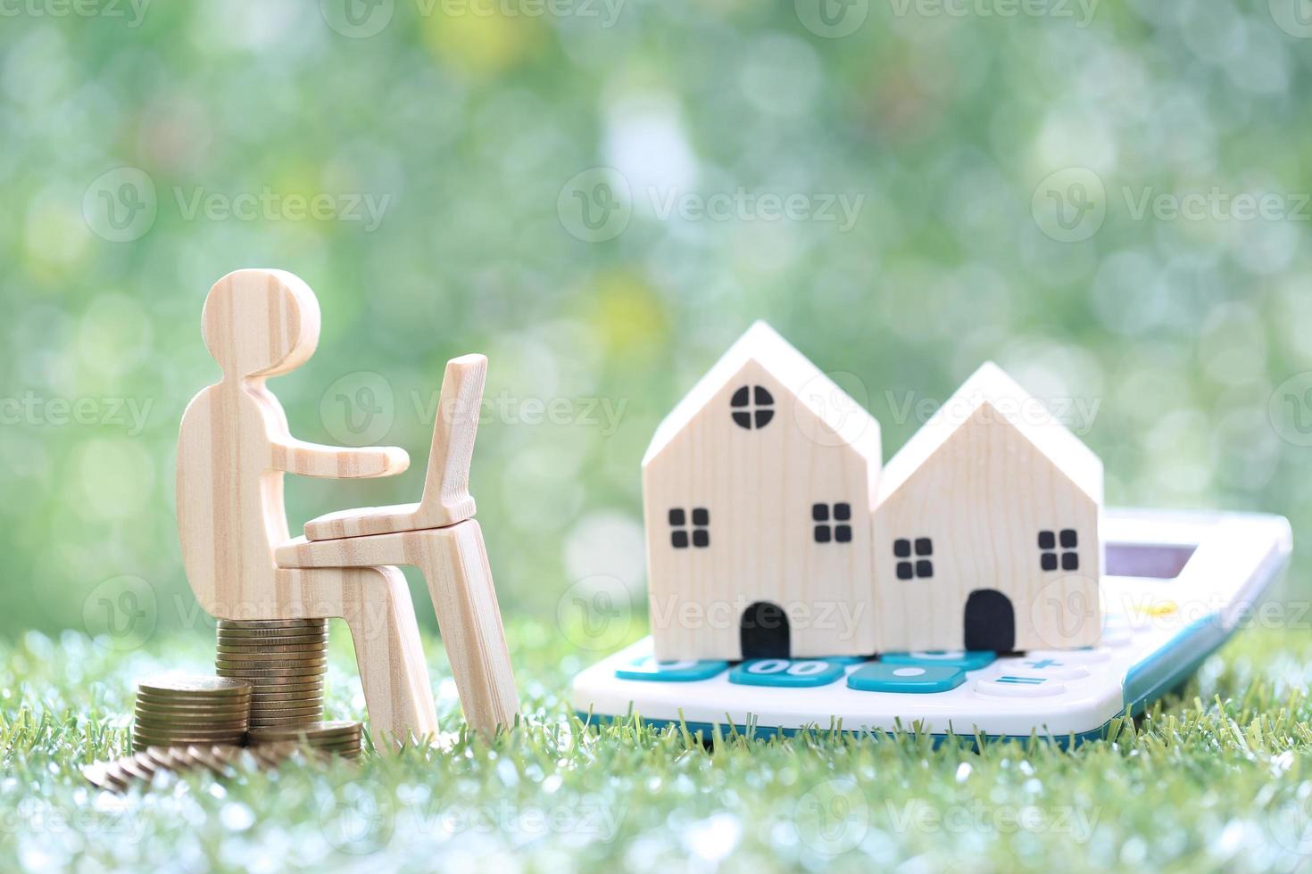 Estate tax,Man using laptop computer and model house on calculator on natural green background,Business investment and Property tax concept photo
