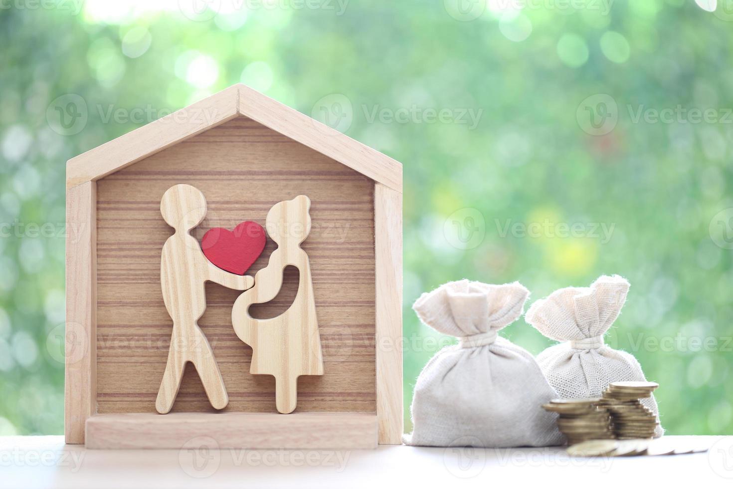 Model family with model house and stack of coins money on natural green background,Save money for prepare in future and family finance concept photo