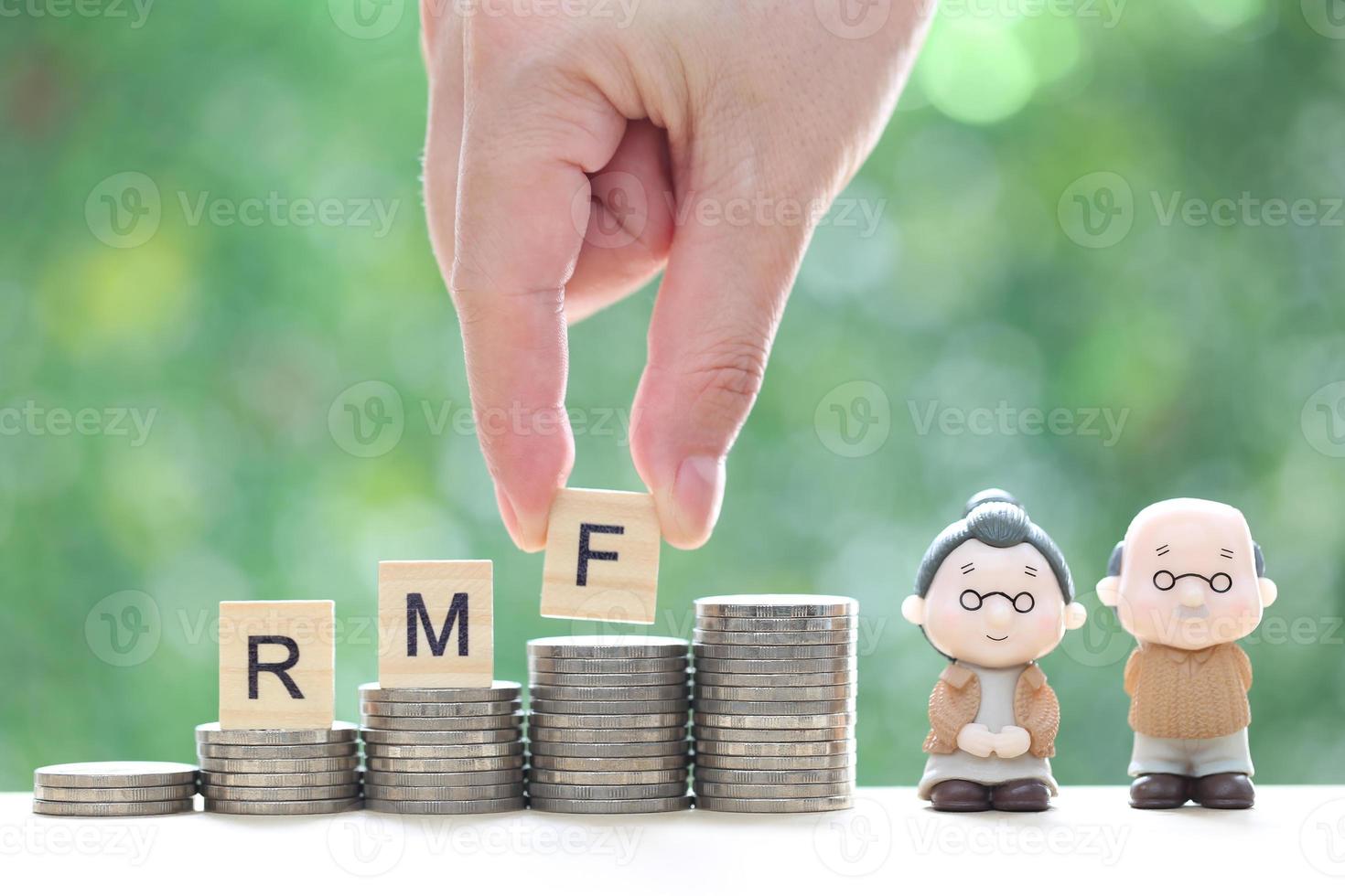 RMF - Retirement Mutual Fund, Love couple senior with RMF word on stack of coins money on natural green background, Save money for prepare in future and pension retirement concept photo