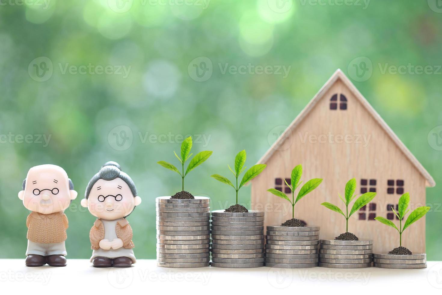 Mutual fund,Love couple senior and model house with stack of coins money on natural green background, Save money for prepare in future and pension retirement concept photo