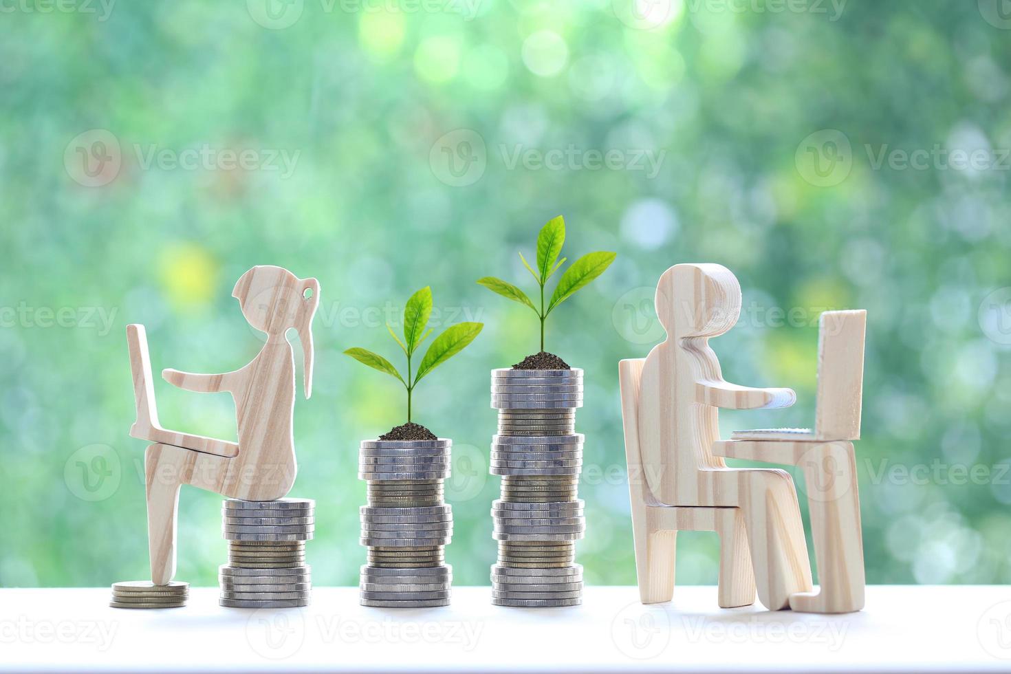 Investment and business concept,Man and woman using laptop computer with stack of coin money on natural green background,Investors strategy photo