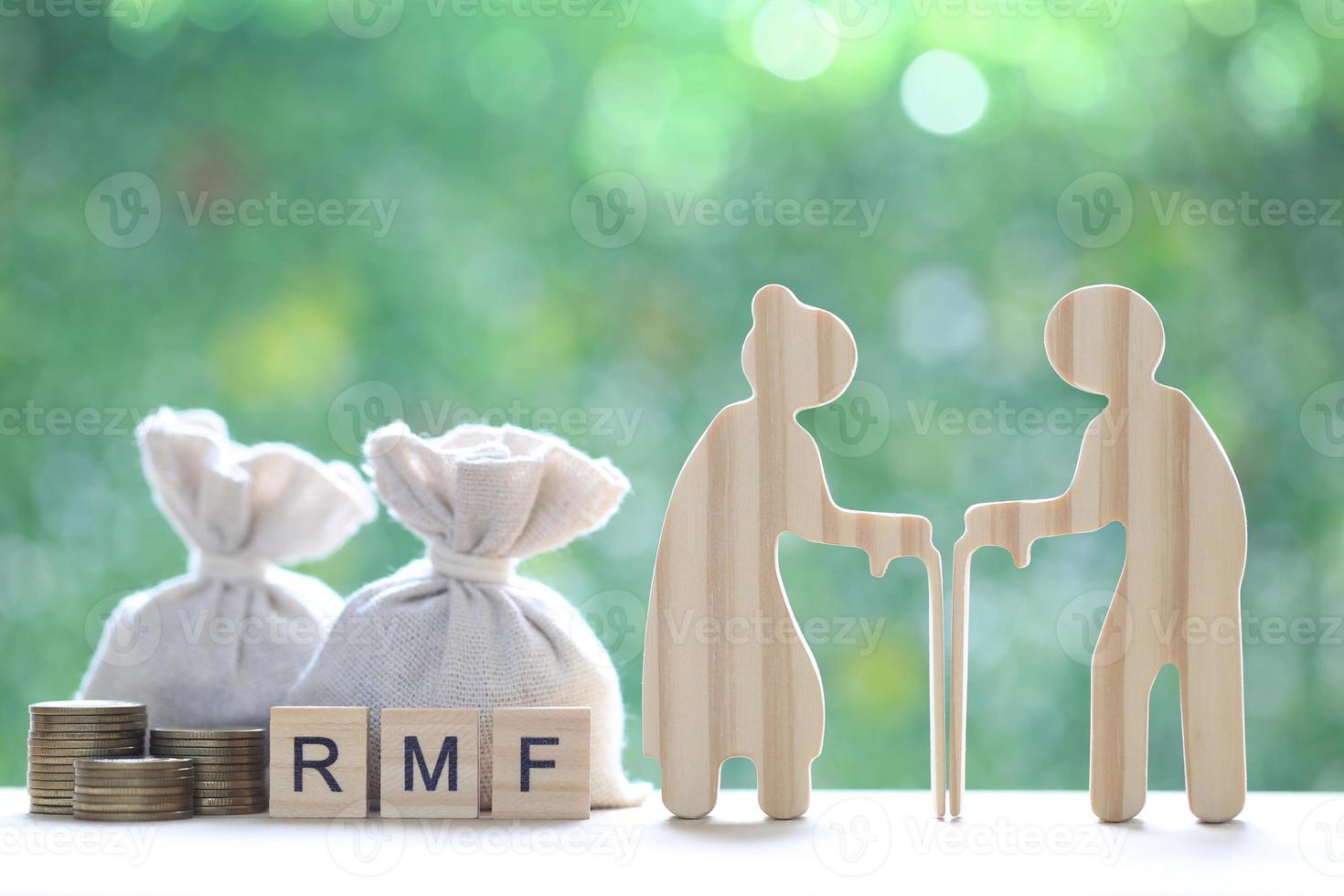 RMF - Retirement Mutual Fund, Senior man with RMF word and stack of coins money on natural green background, Save money for prepare in future and pension retirement concept photo