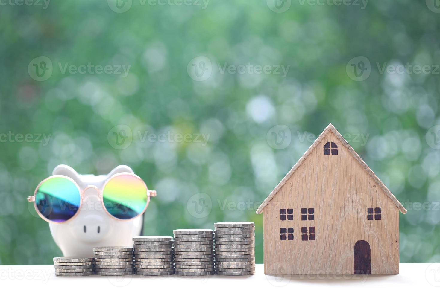 Finance, Model house with stack of coins money on natural green background, Saving money for prepare in future and investment concept photo